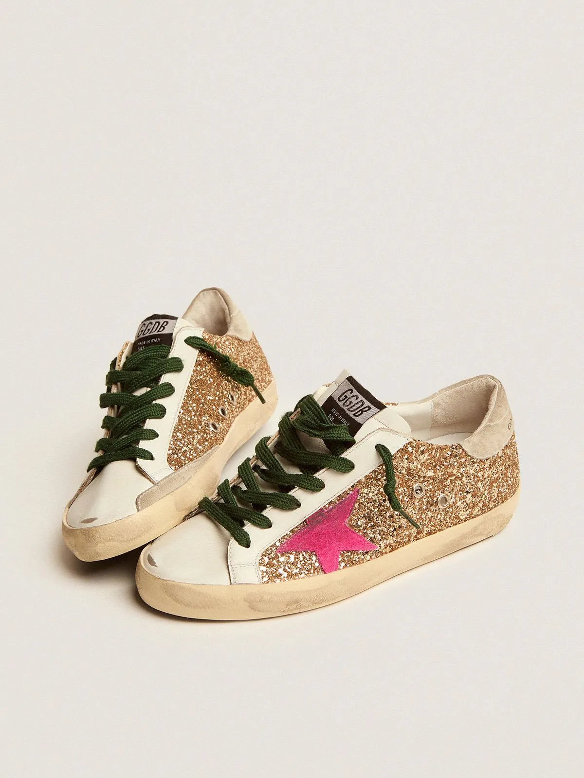 Sneakers Super-Star in glitter oro con stella in camoscio rosa fluo