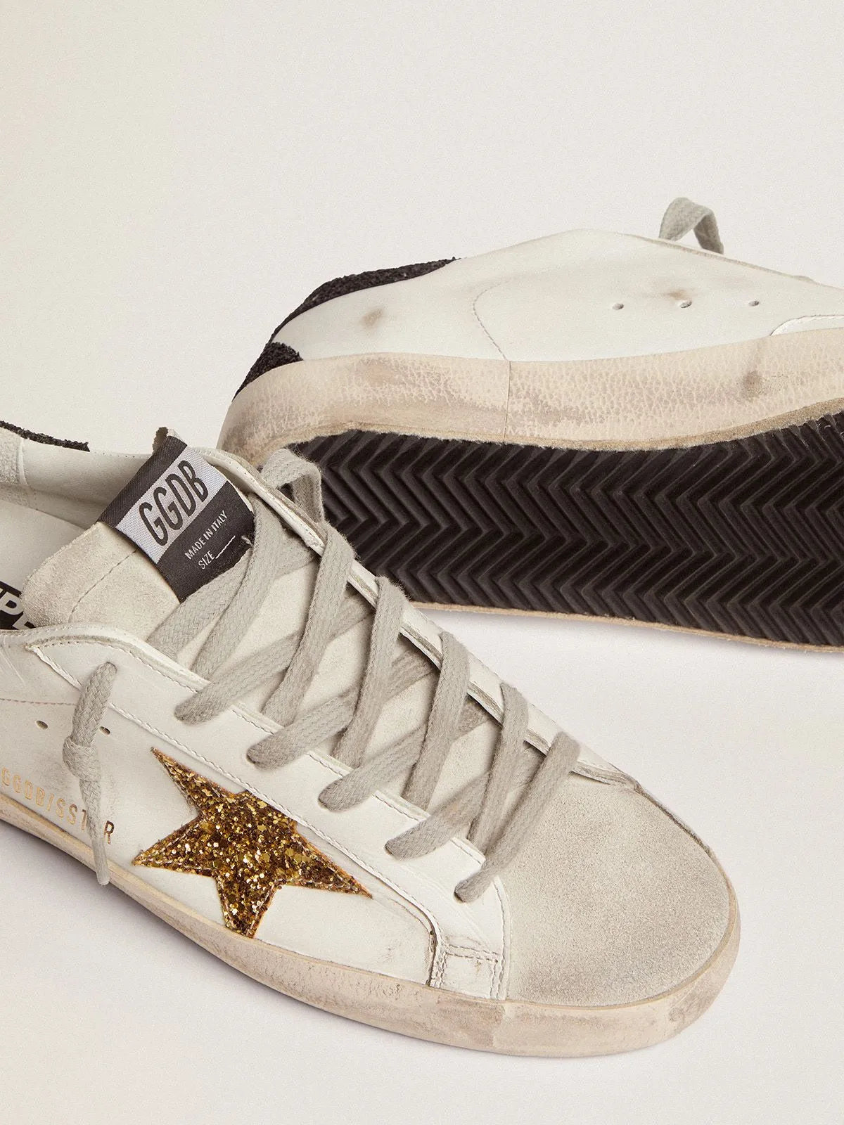 Sneakers Super-Star con stella dorata e talloncino nero glitterato